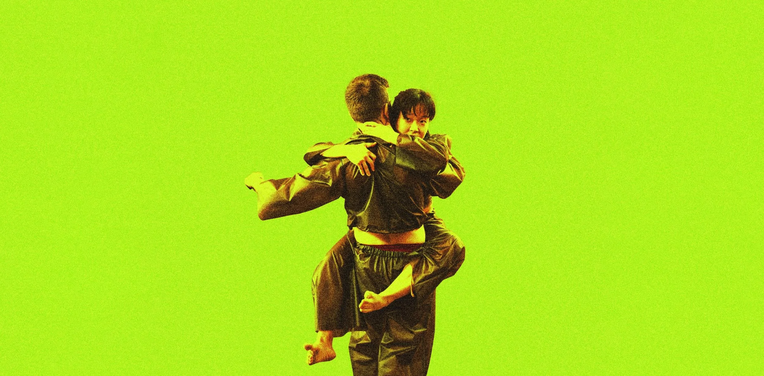 A bright lime green background with a man carrying a woman